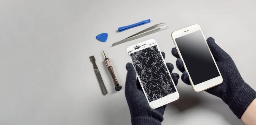 Un teléfono con la pantalla rota junto a una pantalla de recambio y herramientas